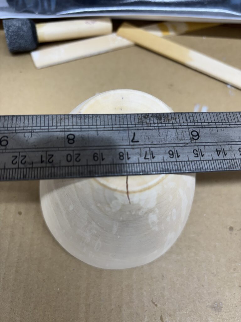 Nat gedraaid perenhout kommetje met barstje.